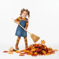 a cute girl sweeping fallen leaves 